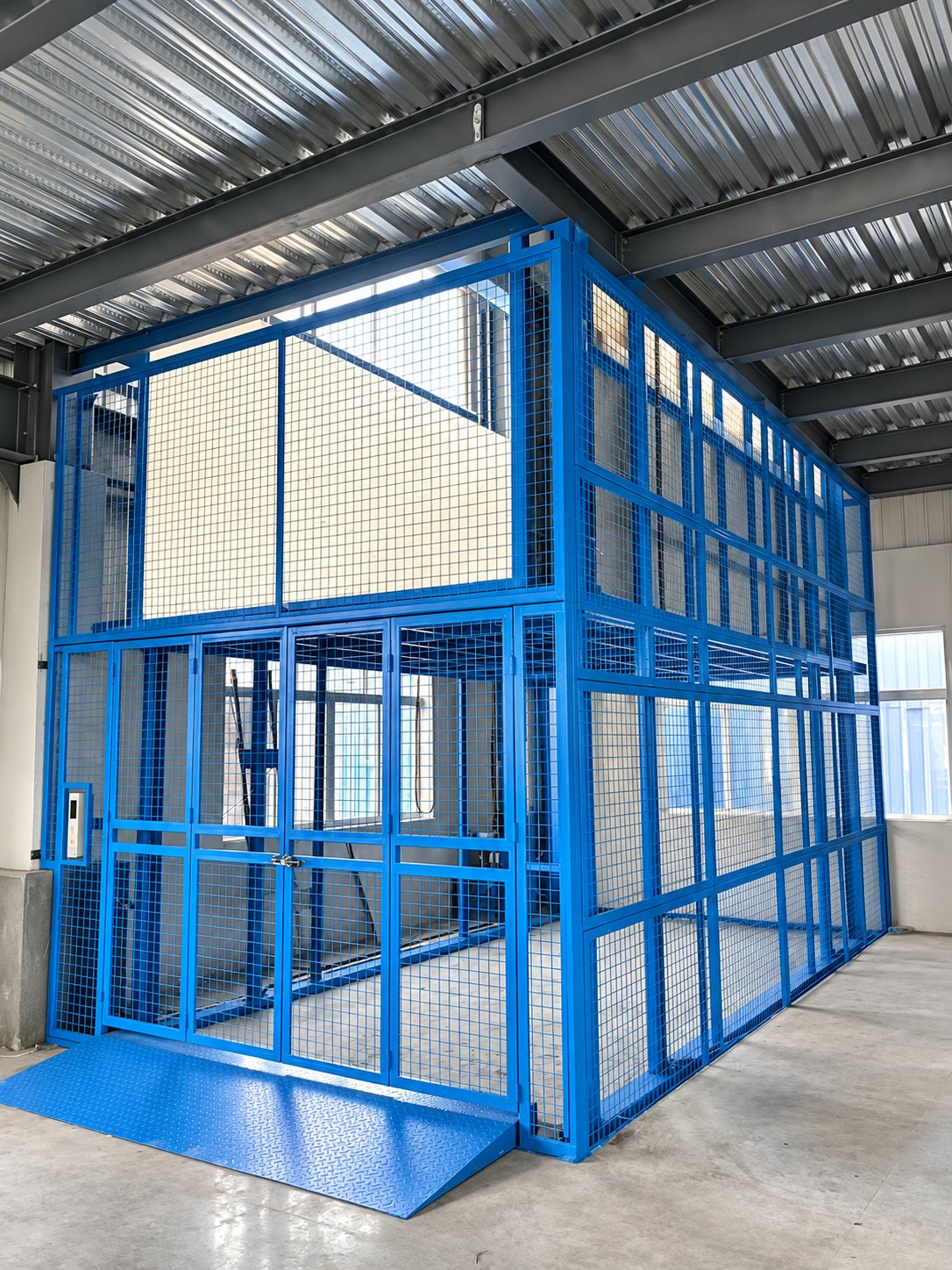 Blue warehouse cargo lift platform with full-height safety enclosure
